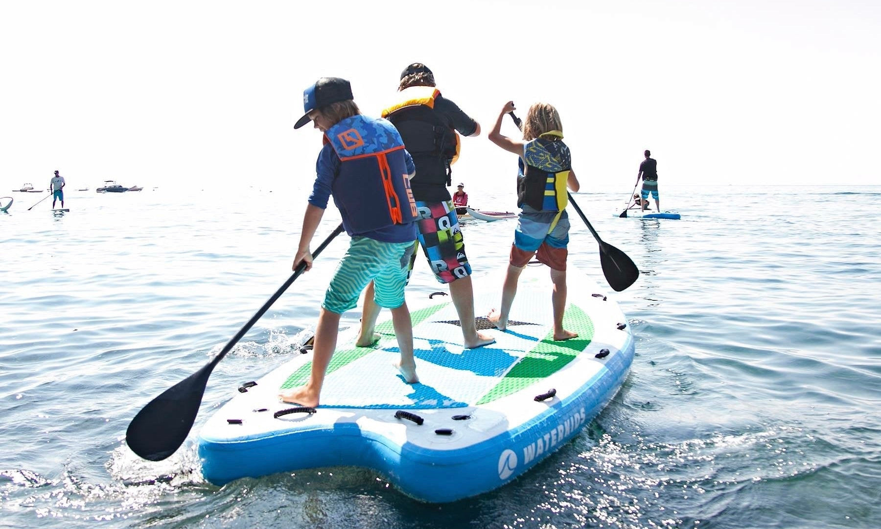 3 kids on giant inflatable paddle board family SUP