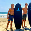 young boy on the beach holding his 4'10 kids surfboard made of foam soft top material safe and durable