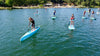 Boy gets ready for kids sup race event.  Group of kids at paddle board school are preparing for a kids paddle board race.  Boy is on his carbon fiber kids race board sup from waterkids