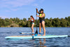 2 girls in paddle board school on their waterkids paddleboards that are specifically for kids.  Girl in the fron is on her tahoe sup model that has a bamboo top and a bungee cord for extra gear 