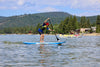 Youth age boy about 12 or 13 years old paddling a waterkids 7'6 Maui Kids Paddle Board surf SUP for children and teens.  Boy is wearing a life jacket and a red hat and is paddling his board from left to right and taking a very powerful stroke with good technique.